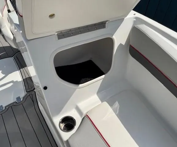 Slide: The Image of Open storage compartment in 2021 Tahoe 700 boat with cushioned seating and cup holder. - 10