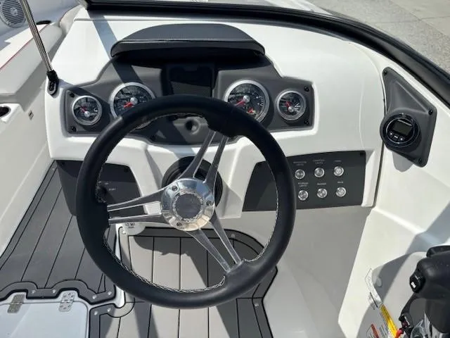 Slide: The Image of Steering wheel and dashboard of 2021 Tahoe 700 boat, featuring gauges and controls. - 15