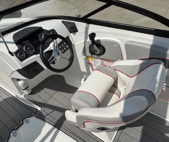 Slide: The Image of 2021 Tahoe 700 boat interior with steering wheel, dashboard, and cushioned seat. - 17