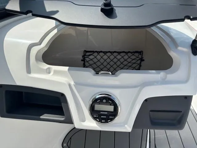 Slide: The Image of 2021 Tahoe 700 boat dashboard with storage compartment and audio controls. - 19