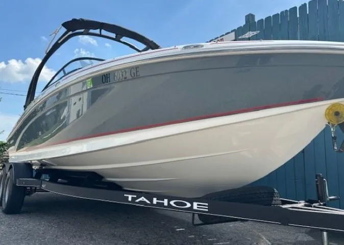 Slide: The Image of 2021 Tahoe 700 boat on trailer under blue sky. - 2