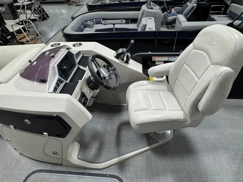 Slide: The Image of 2020 Manitou 23 Oasis RF boat cockpit with steering wheel and plush captain's chair. - 10