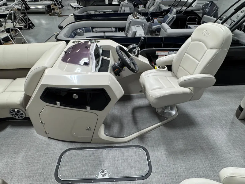 Slide: The Image of 2020 Manitou 23 Oasis RF boat interior with steering console and plush seating. - 12