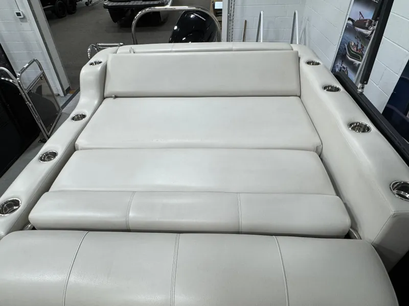 Slide: The Image of 2020 Manitou 23 Oasis RF boat interior with white cushioned seating and cup holders. - 17