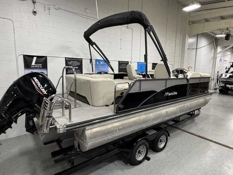 Slide: The Image of 2020 Manitou 23 Oasis RF pontoon boat with Mercury engine on trailer in showroom. - 3