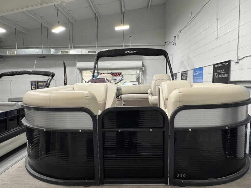 Slide: The Image of 2020 Manitou 23 Oasis RF pontoon boat with beige seating in a showroom. - 5