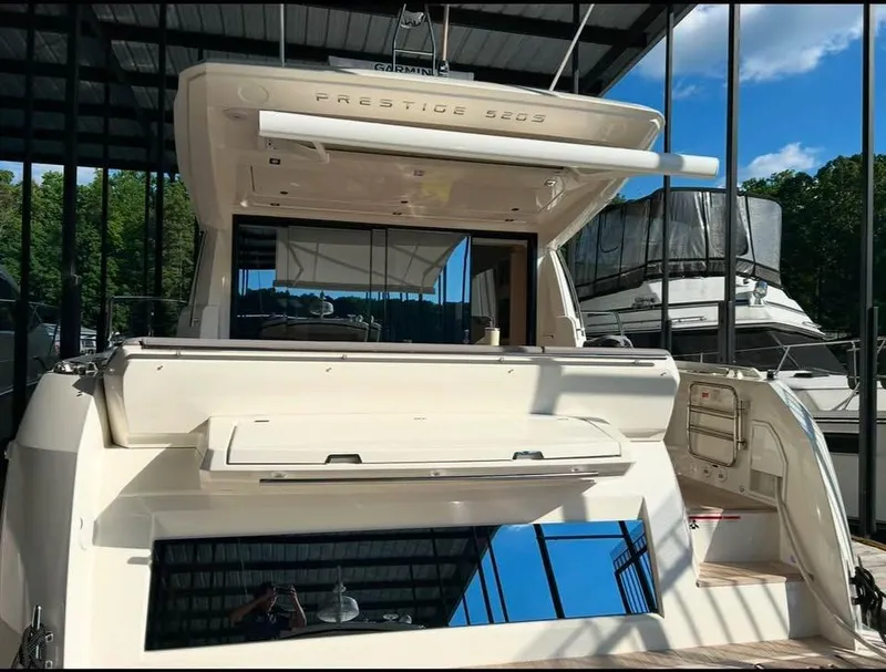 Slide: The Image of 2023 Prestige 520S yacht docked under a canopy, showcasing sleek design and modern features. - 2