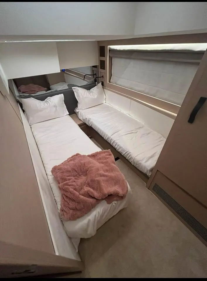 Slide: The Image of 2023 Prestige 520S yacht cabin with twin beds and cozy decor. - 8