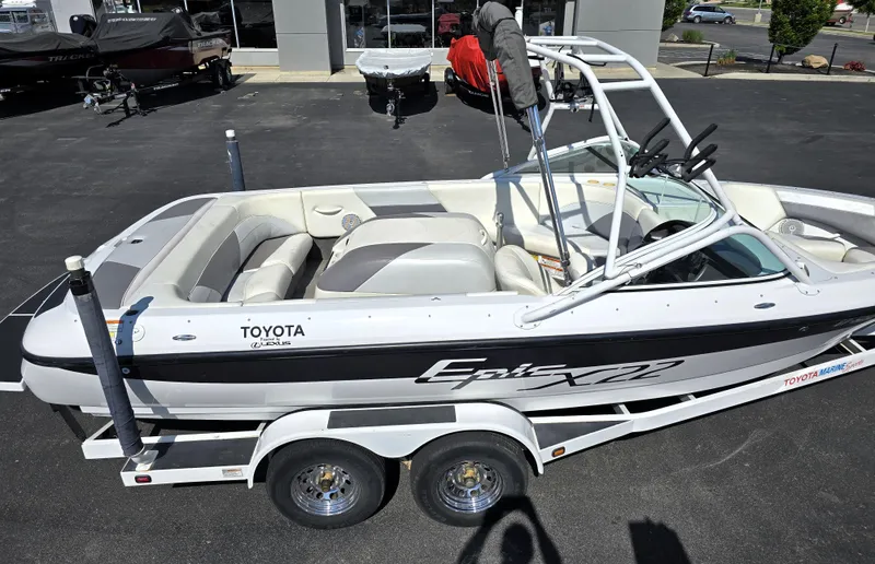 Slide: The Image of 2000 Toyota Epic 22 boat on trailer, parked outdoors, showcasing sleek design and seating. - 11