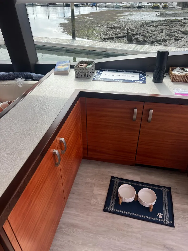 Slide: The Image of Interior of 2011 Hatteras 60 Motor Yacht with wooden cabinets and pet bowls on mat. - 10