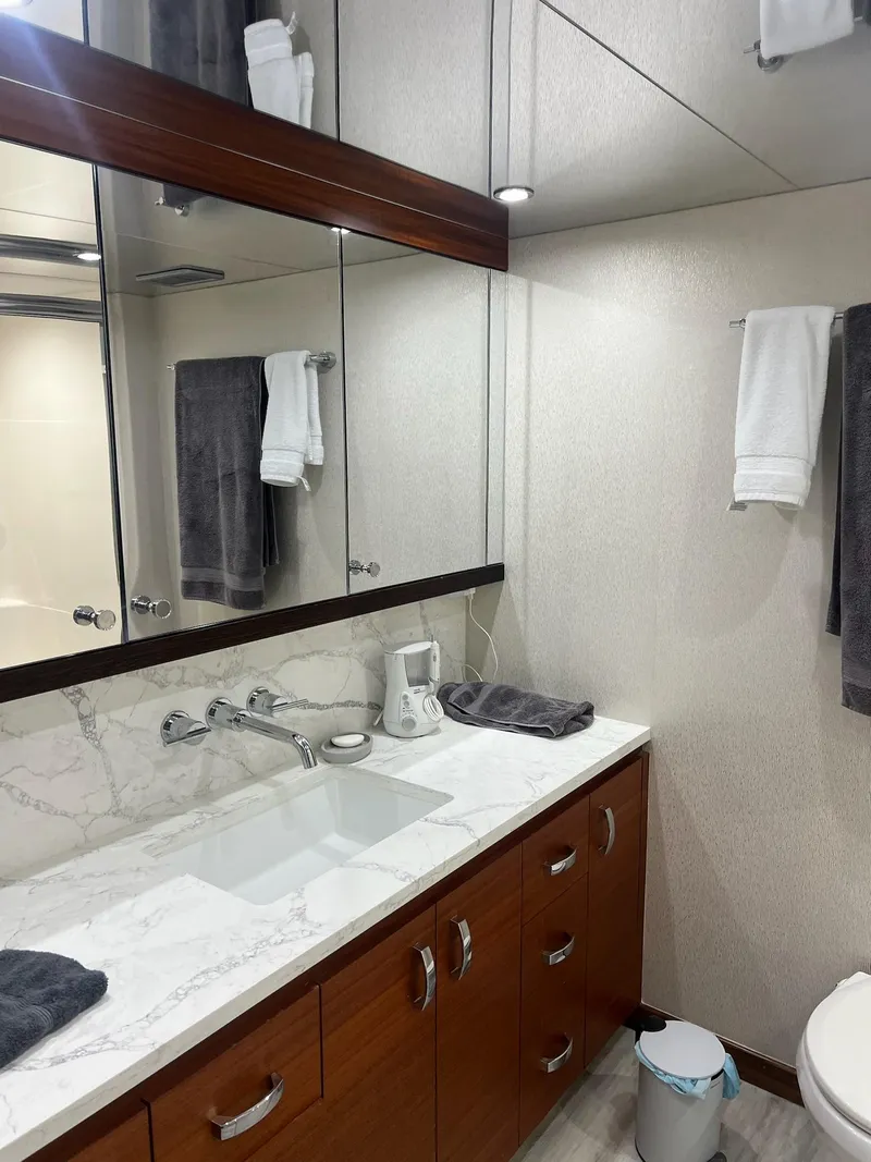 Slide: The Image of Luxurious bathroom in 2011 Hatteras 60 Motor Yacht with marble countertop and wooden cabinetry. - 12