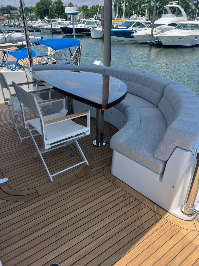 Slide: The Image of Luxurious seating area on 2011 Hatteras 60 Motor Yacht with wooden deck and marina view. - 13