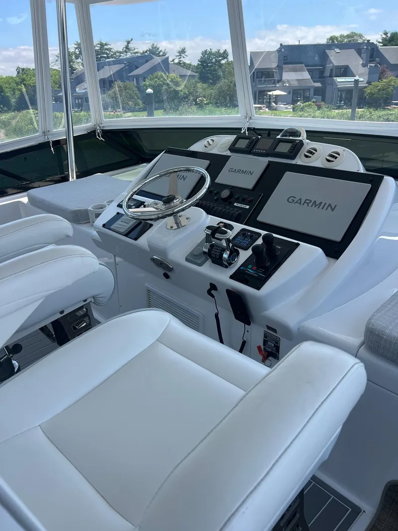 Slide: The Image of Helm of 2011 Hatteras 60 Motor Yacht with Garmin navigation systems and white seating. - 16