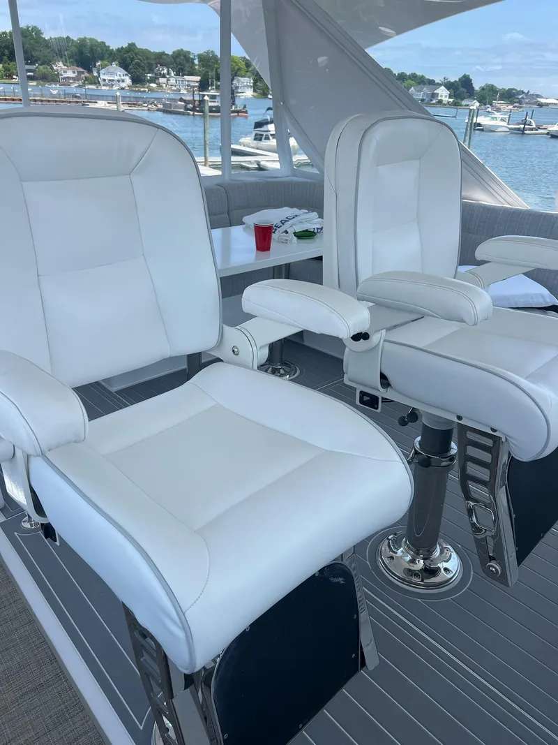 Slide: The Image of Luxurious white seating on 2011 Hatteras 60 Motor Yacht, overlooking marina. - 19