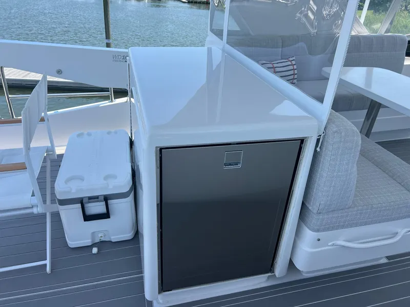 Slide: The Image of 2011 Hatteras 60 Motor Yacht deck with cooler and seating area. - 22