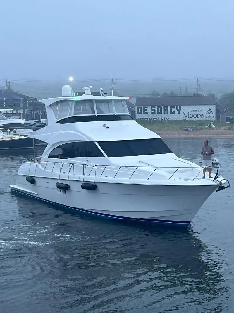 Slide: The Image of 2011 Hatteras 60 Motor Yacht on misty water near a dock. - 26