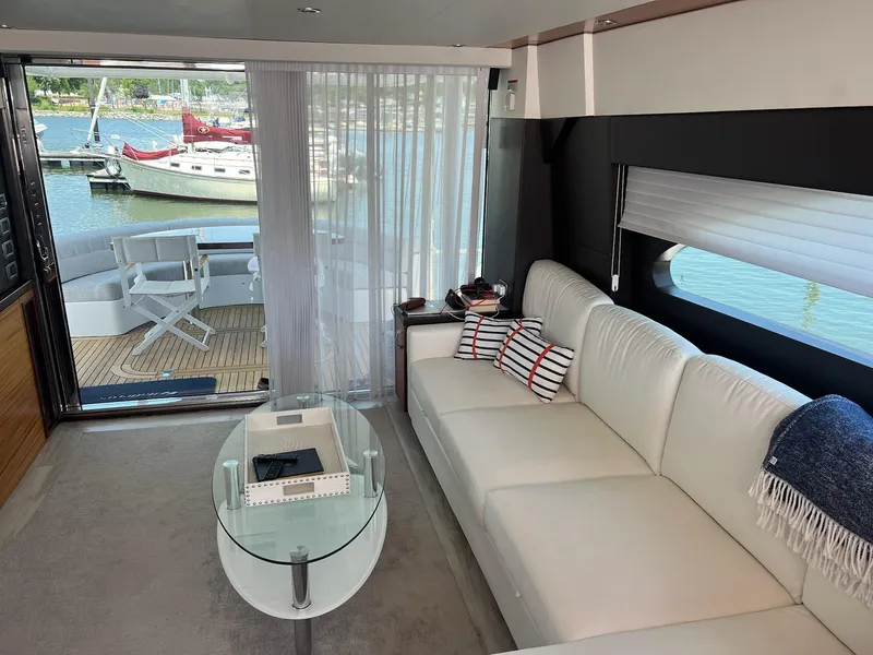 Slide: The Image of Luxurious interior of 2011 Hatteras 60 Motor Yacht with white sofa and marina view. - 3