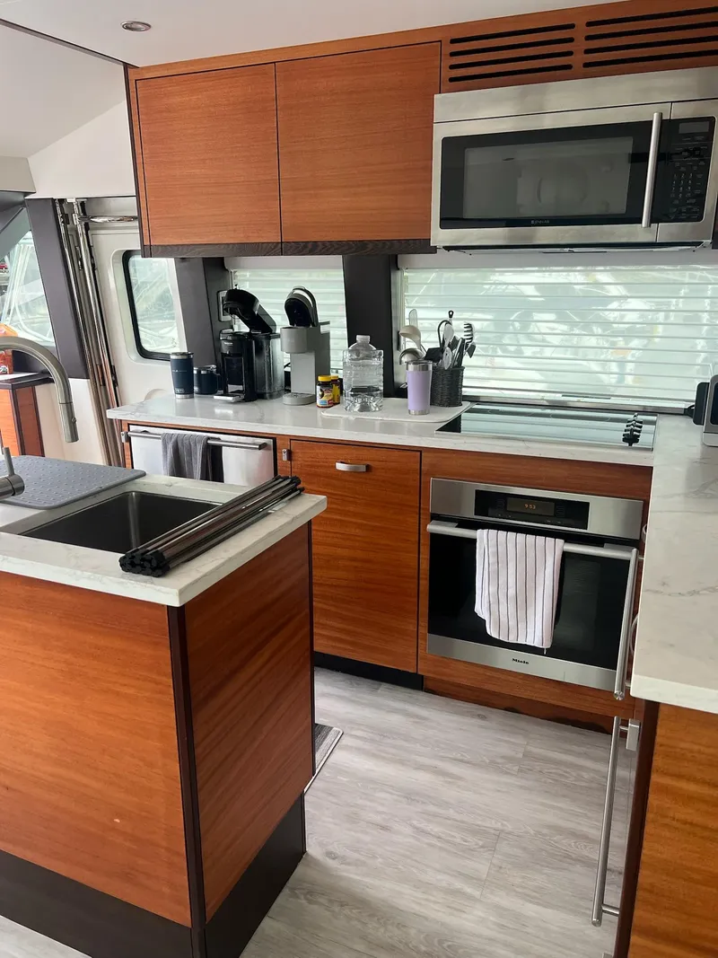 Slide: The Image of Modern kitchen interior on 2011 Hatteras 60 Motor Yacht with wood cabinetry and stainless steel appliances. - 6