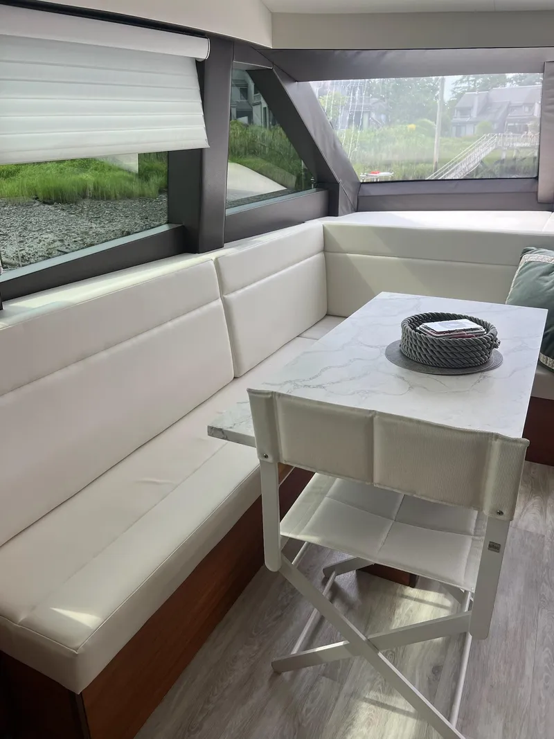 Slide: The Image of Luxurious interior of 2011 Hatteras 60 Motor Yacht with white seating and table. - 9