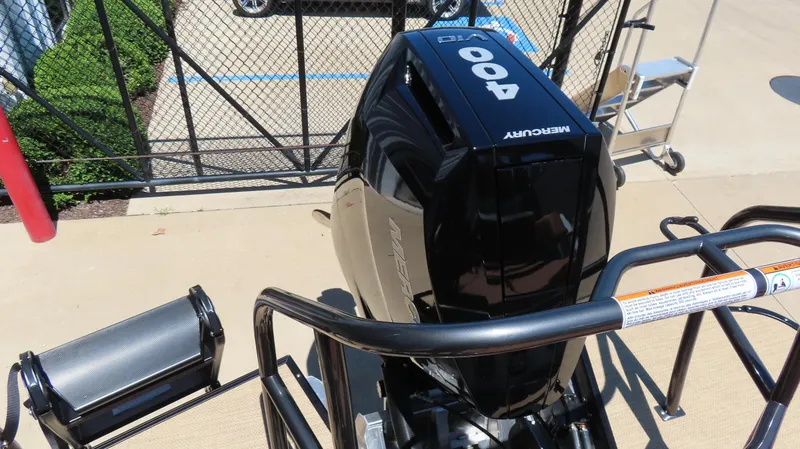 Slide: The Image of 2025 Princecraft Vogue 27 RL with Mercury 400 outboard motor, docked near a fence. - 10