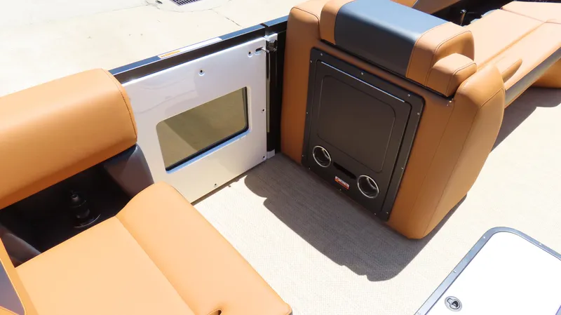 Slide: The Image of 2025 Princecraft Vogue 27 RL boat interior with tan seating and storage compartment. - 15