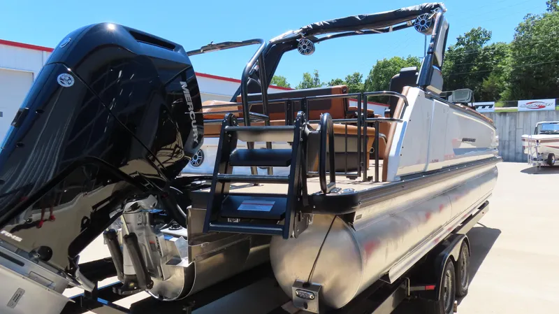 Slide: The Image of 2025 Princecraft Vogue 27 RL pontoon boat with Mercury engine, docked outdoors. - 8