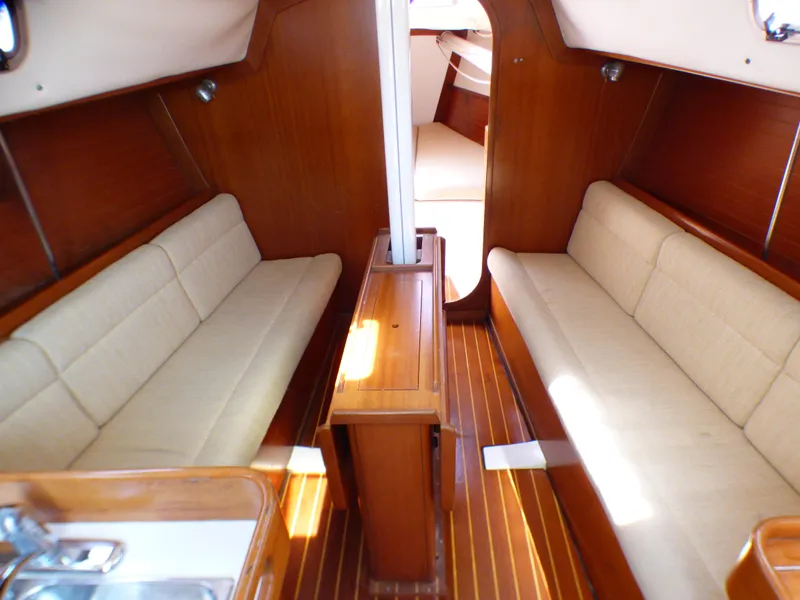 Slide: The Image of Interior of 2002 J Boats J/109 sailboat with wooden finish and beige seating. - 13