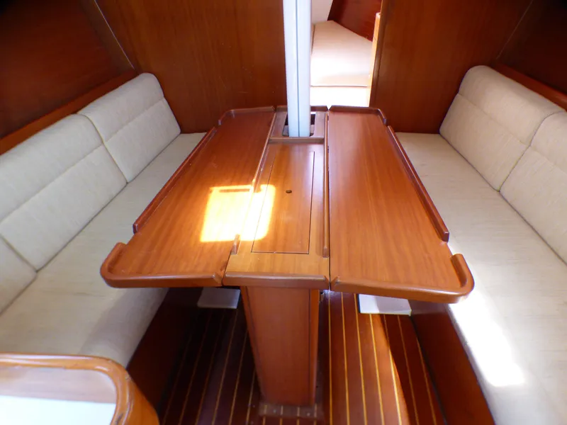 Slide: The Image of Interior of 2002 J Boats J/109 sailboat with wooden table and cushioned seating. - 14