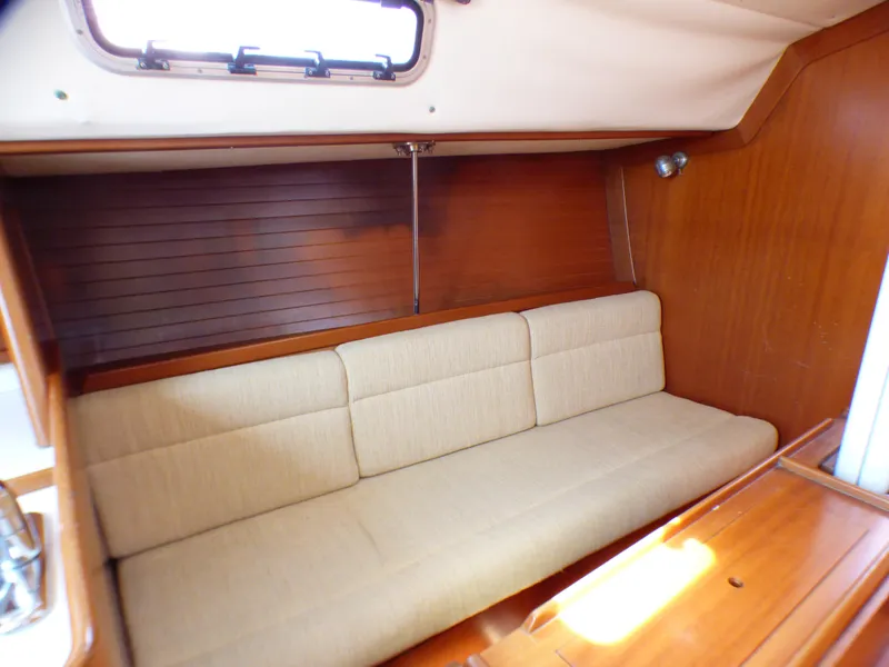 Slide: The Image of Interior of 2002 J Boats J/109 sailboat with beige cushioned seating and wooden paneling. - 15