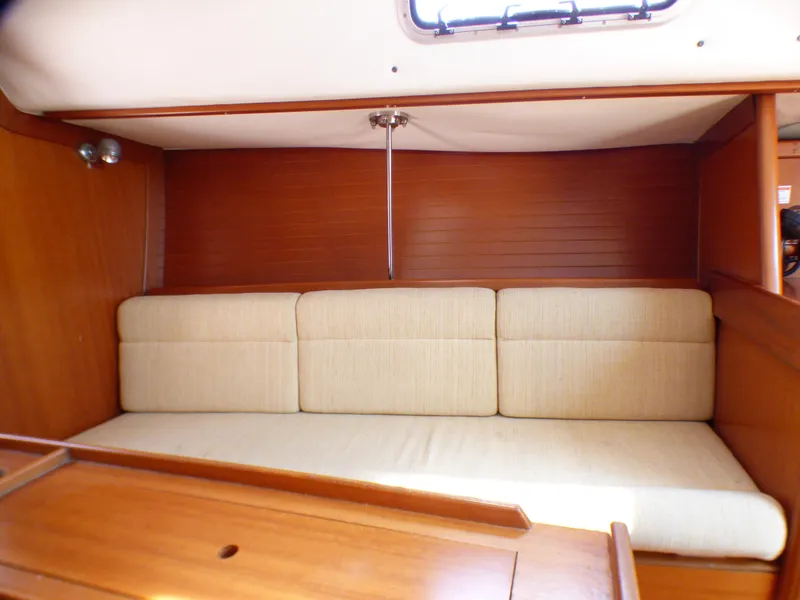 Slide: The Image of Interior of 2002 J Boats J/109 sailboat with beige cushioned seating and wooden paneling. - 16