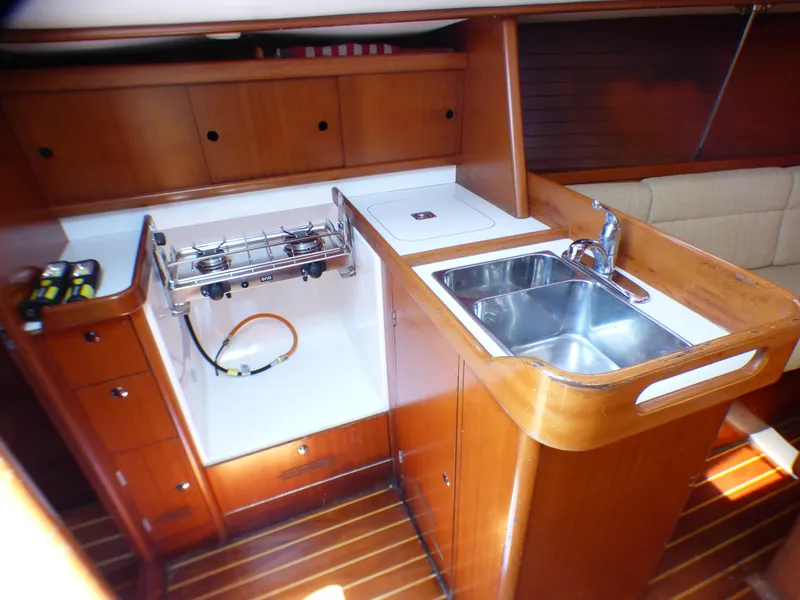 Slide: The Image of Interior of 2002 J Boats J/109 yacht featuring a compact kitchen with stove and sink. - 18