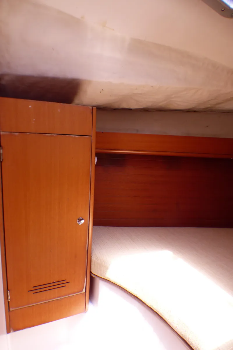 Slide: The Image of 2002 J Boats J/109 interior cabin with wooden cabinet and cozy sleeping area. - 25