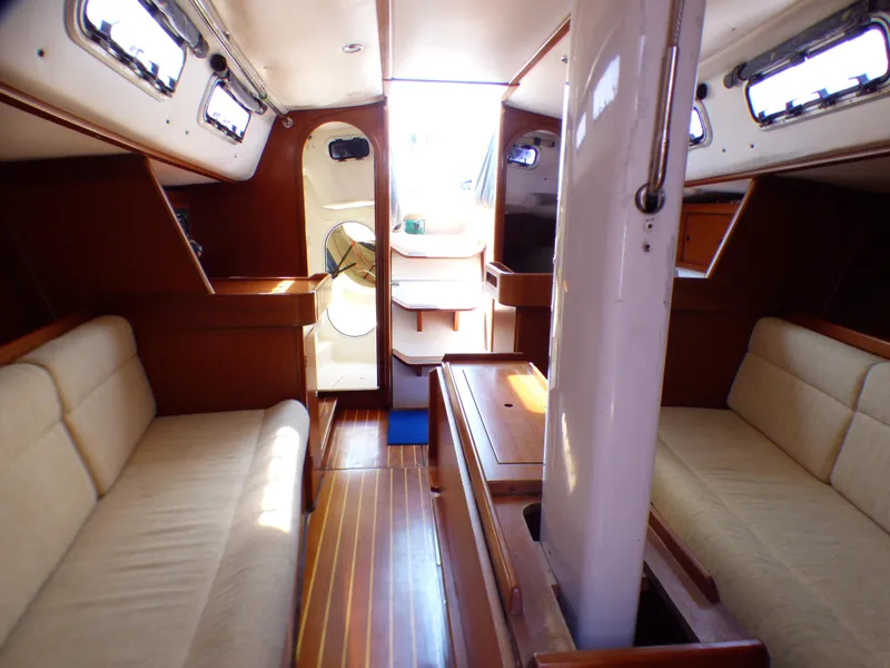 Slide: The Image of Interior of 2002 J Boats J/109 sailboat with wooden finishes and beige seating. - 27