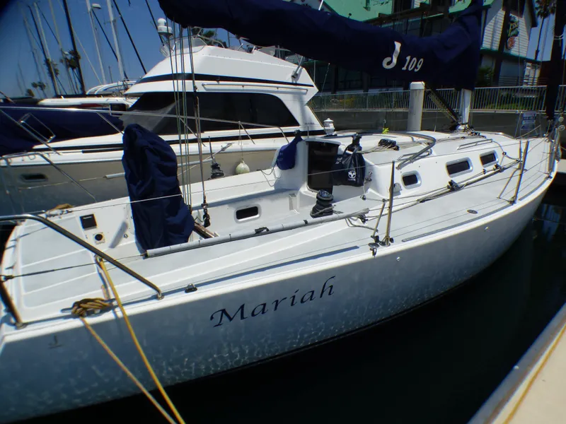 Slide: The Image of 2002 J Boats J/109 sailboat docked, named "Mariah," with blue covers and sleek design. - 34