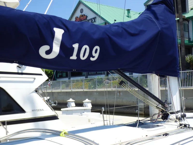 Slide: The Image of Sailboat with blue cover displaying "J 109" docked at marina, J Boats model 2002. - 37