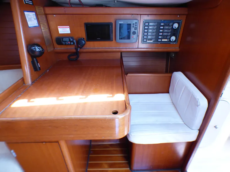Slide: The Image of 2002 J Boats J/109 interior with navigation station and cushioned seating. - 5
