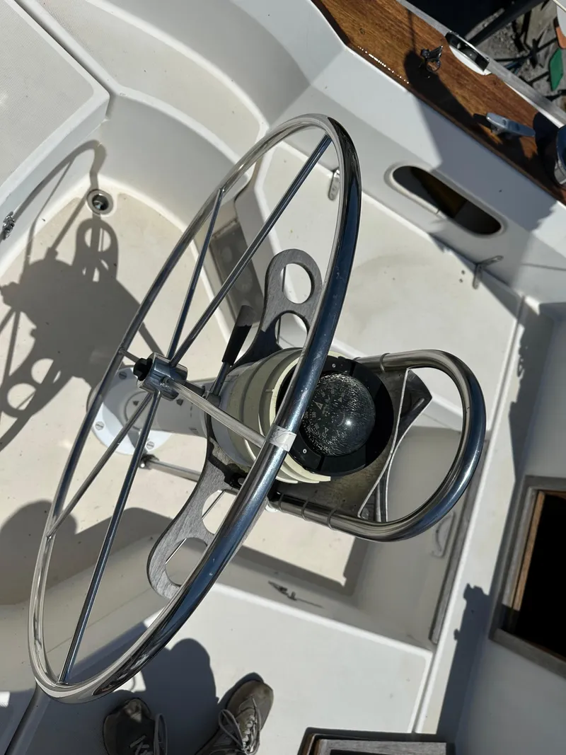 Slide: The Image of 1986 Sabre 32 sailboat cockpit with steering wheel and compass. - 14