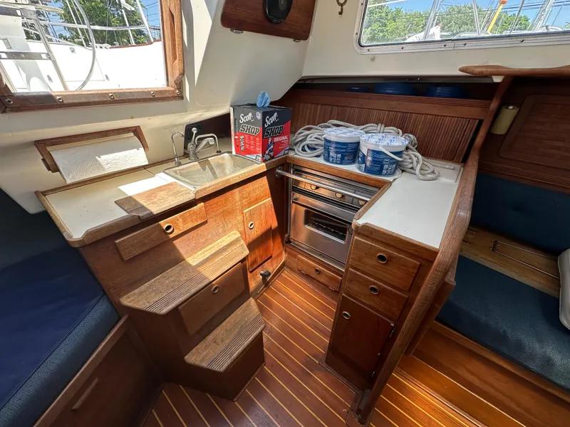 Slide: The Image of Interior of 1986 Sabre 32 sailboat galley with wood cabinetry and compact kitchen amenities. - 18