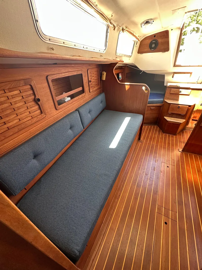 Slide: The Image of 1986 Sabre 32 sailboat interior with wooden finish and blue cushioned seating. - 19
