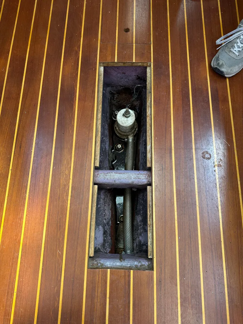 Slide: The Image of Wooden boat deck with open hatch, revealing mechanical components. Sabre 32, 1986 model. - 25