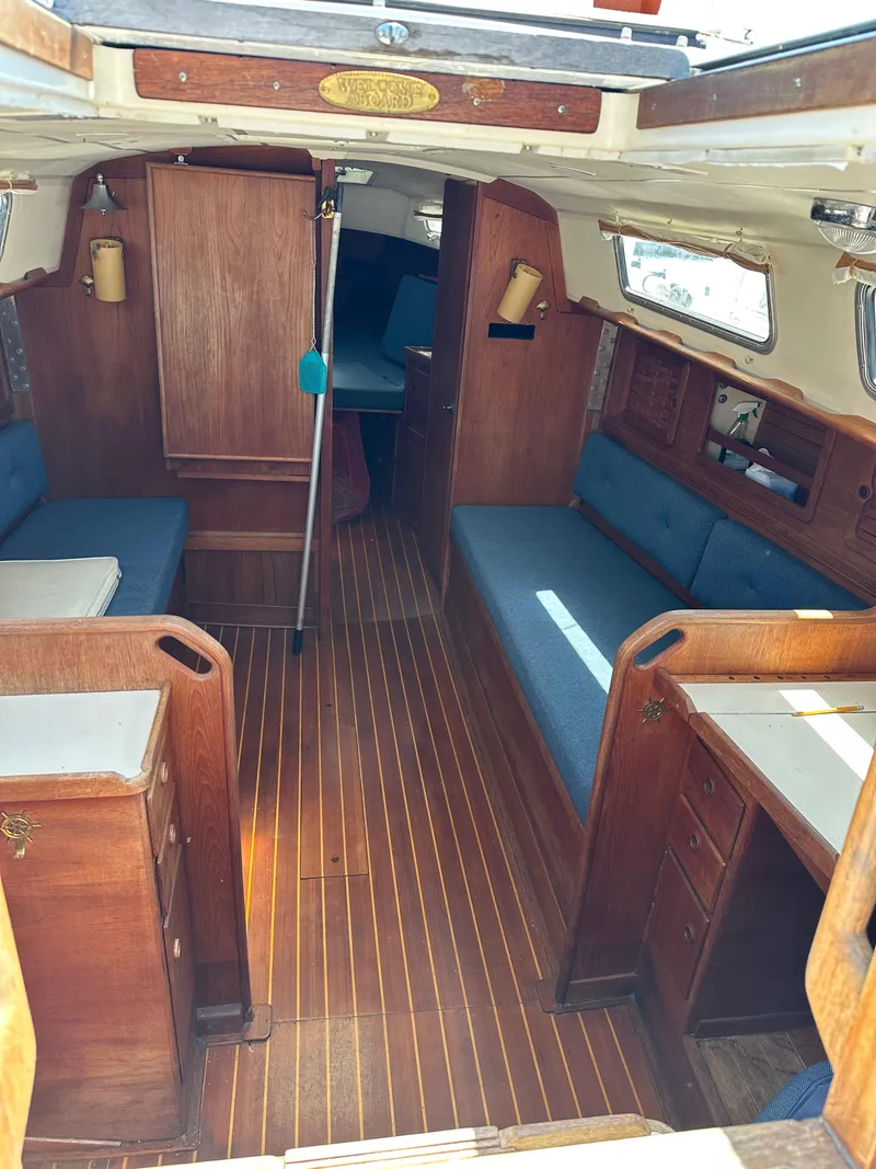 Slide: The Image of Interior of a 1986 Sabre 32 sailboat with wooden furnishings and blue cushions. - 8