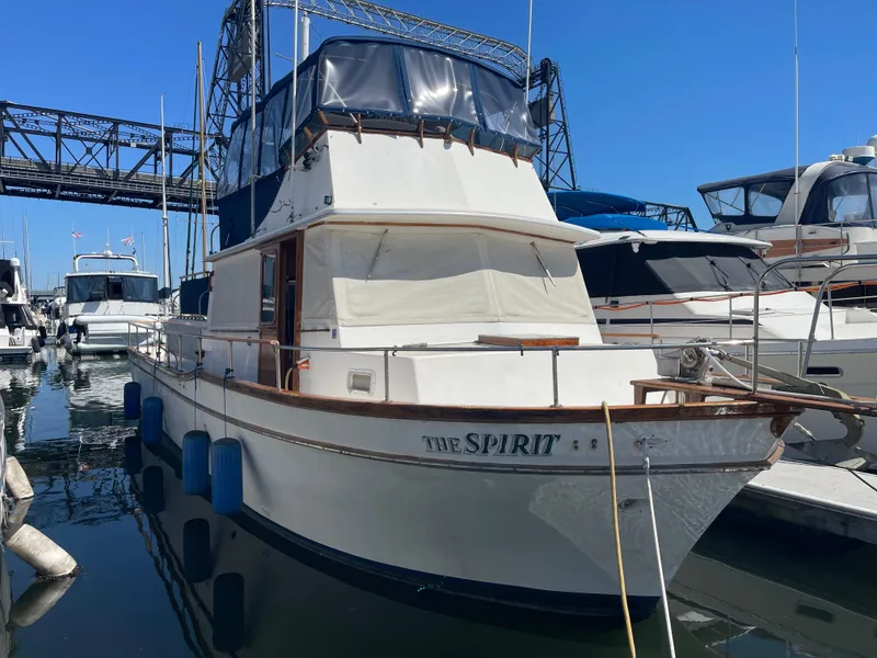 The Image of 1978 Californian Tri-Cabin Trawler docked at marina under clear blue sky. - 1