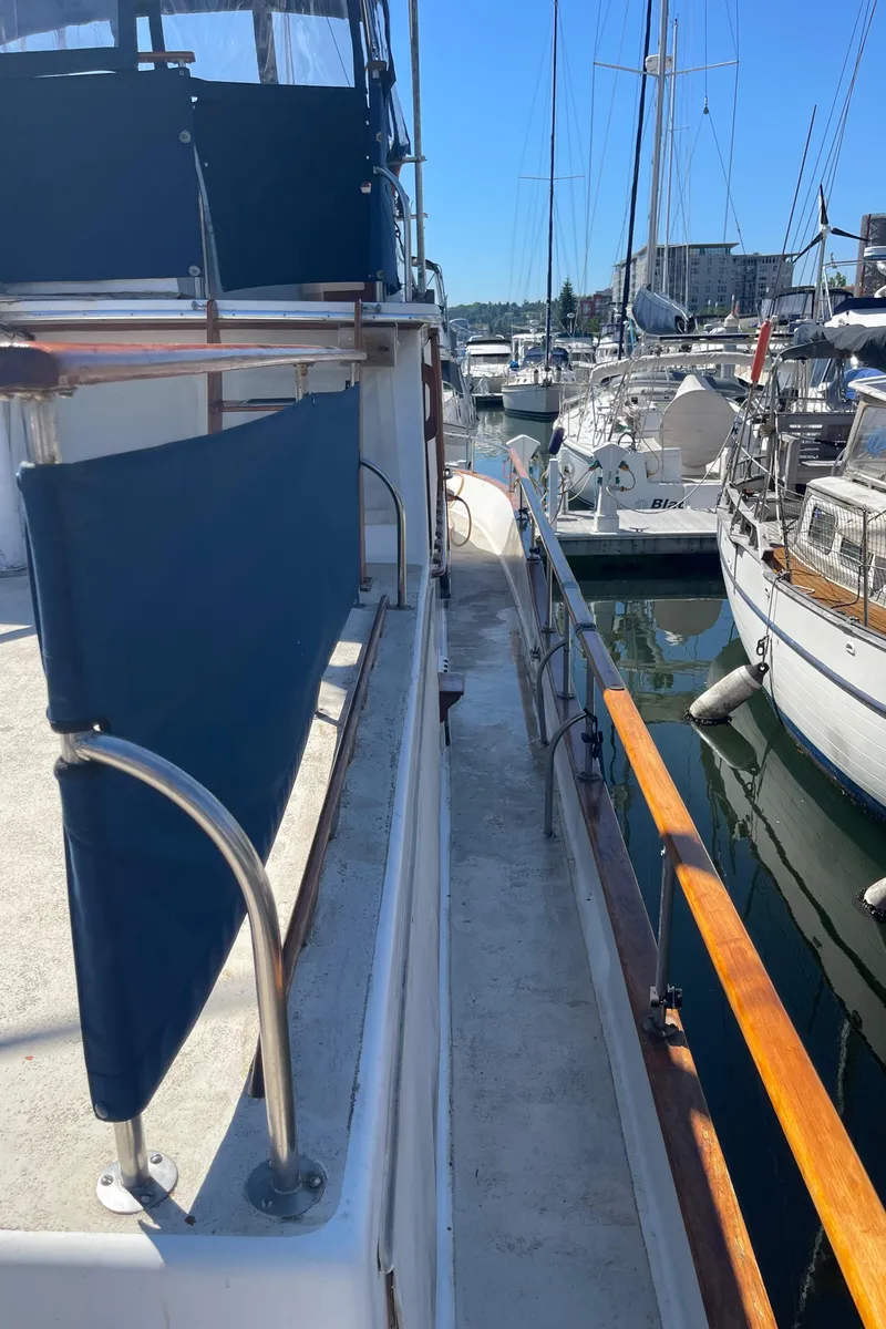 Slide: The Image of 1978 Californian Tri-Cabin Trawler docked in a marina, surrounded by other boats. - 10