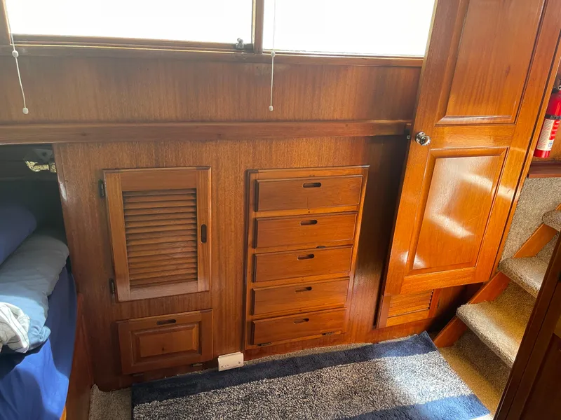 Slide: The Image of 1978 Californian Tri-Cabin Trawler interior with wooden cabinets and drawers, carpeted floor, and stairs. - 20