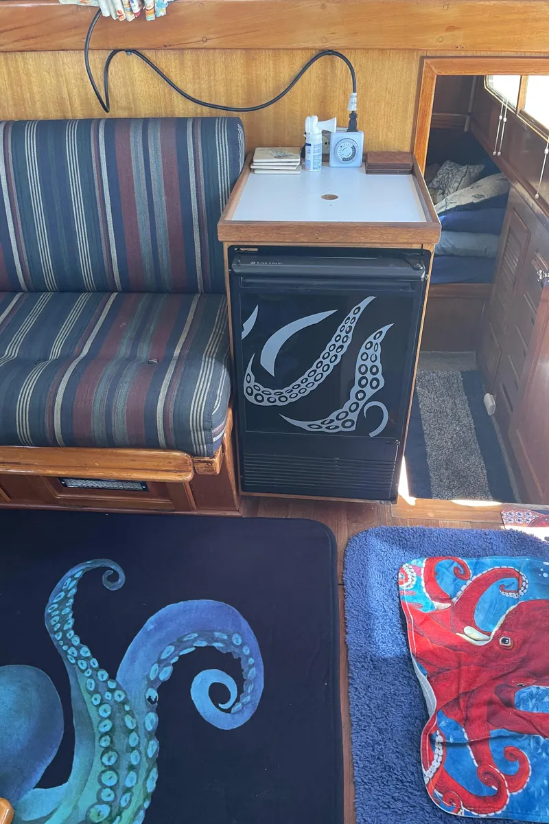 Slide: The Image of 1978 Californian Tri-Cabin Trawler interior with octopus-themed decor and striped seating. - 24