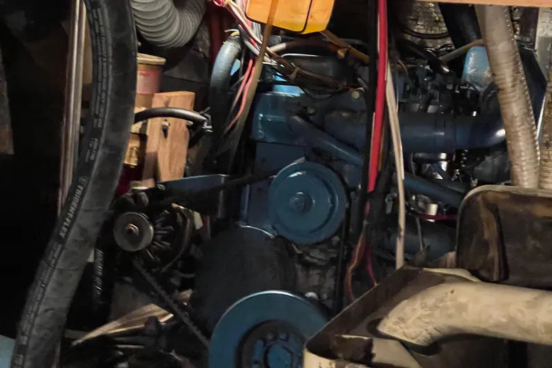Slide: The Image of Engine room of a 1978 Californian Tri-Cabin Trawler with visible machinery and hoses. - 25