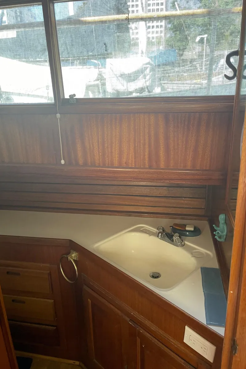 Slide: The Image of 1978 Californian Tri-Cabin Trawler bathroom with wooden cabinetry and sink. - 26
