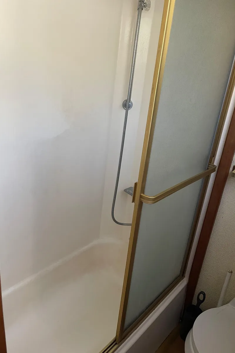 Slide: The Image of Shower area in 1978 Californian Tri-Cabin Trawler with gold trim and sliding door. - 28