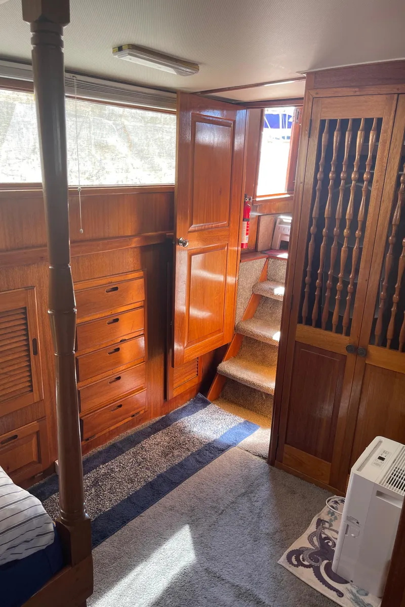 Slide: The Image of 1978 Californian Tri-Cabin Trawler interior with wooden cabinetry and carpeted stairs. - 29
