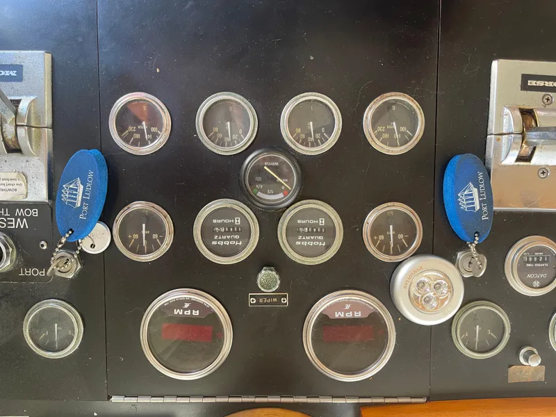 Slide: The Image of 1978 Californian Tri-Cabin Trawler dashboard with gauges and controls, featuring Port Ludlow keychains. - 31